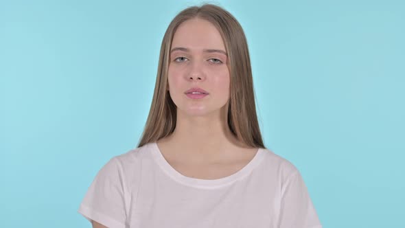 Beautiful Young Woman Saying No with Finger Sign, Blue Background