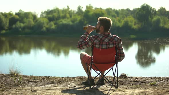 Drunk Man Sitting on River Bank, Admiring View and Resting, Spending Weekend