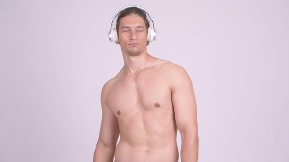 Handsome Muscular Shirtless Man Dancing While Listening To Music