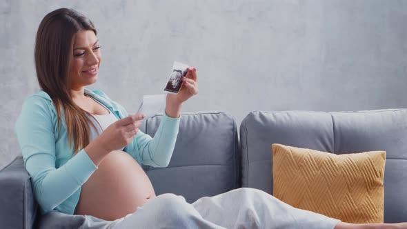 Young pregnant woman is resting at home and expecting a baby.