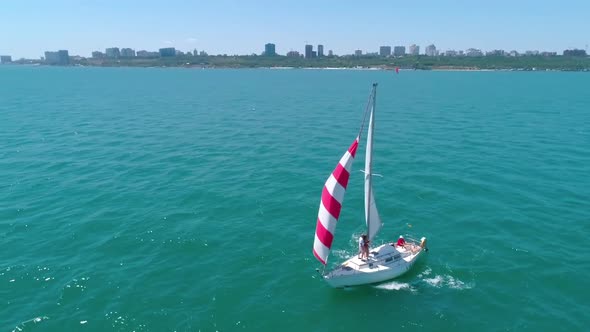 Yacht sailing in open sea. Aerial view of yacht sailing in the bay