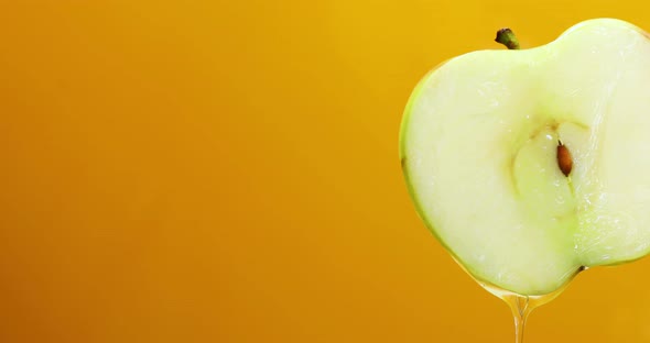 Apple juice dripping from fresh sliced green apple, isolated