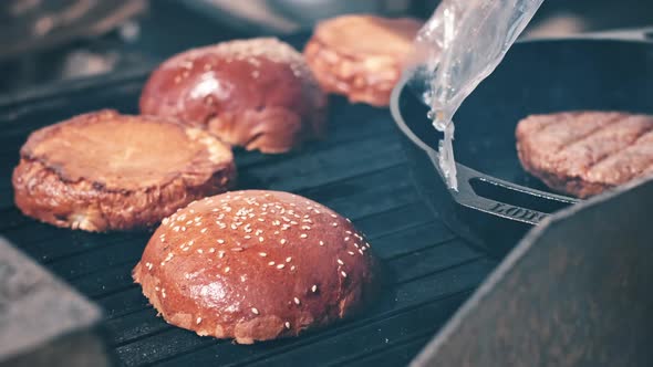 Frying patties and burger buns in a frying pan and grill. BBQ