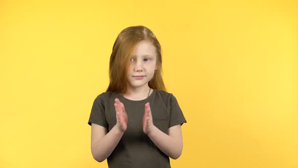 Pretty Girl Claps Happily on Yellow Background