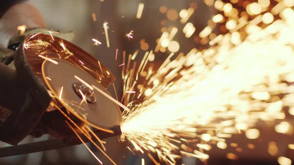 Close Up of Worker Using Cutting Wheel with Sparks