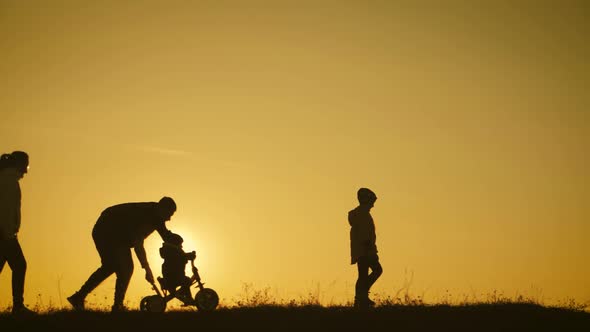 Silhouettes Family Is Together at Sunset