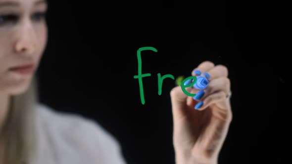 A Girl with White Hair Writes the Word Freegan on a Transparent Board