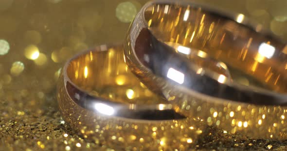 Wedding Gols Rings Lying on Shiny Glossy Surface. Shining with Light