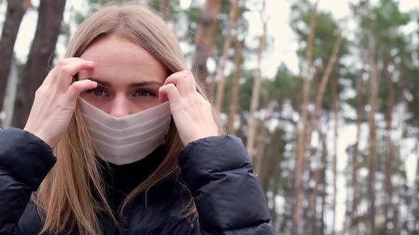 Young Woman Takes Off Protective Face Mask and Breathes Deeply and Smiling Looking at Camera