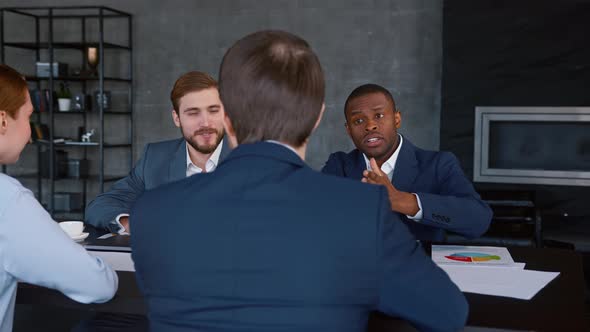 Multiracial business team working together at a corporate briefing gathered around a table