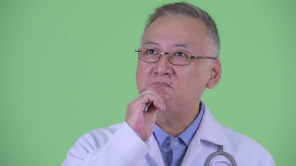 Happy Mature Japanese Man Doctor Thinking