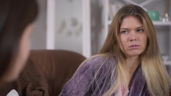 Portrait of Rude Young Beautiful Woman Showing Tongue Fighting Hands with Friend Indoors