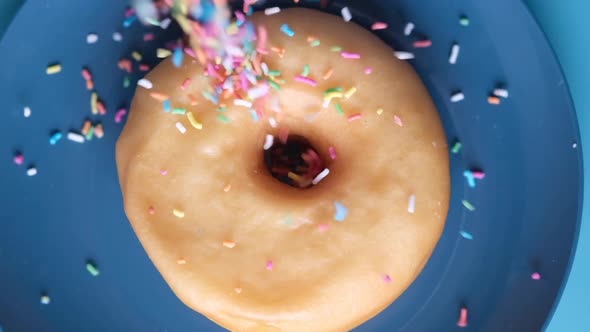 Slow Motion of Dropping Sprinkles on Chocolate Donuts