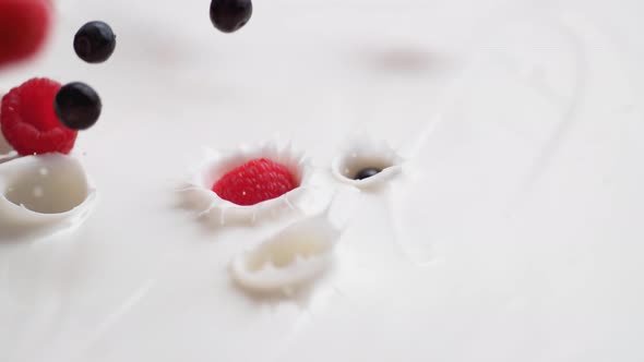 Tossing blueberries and raspberries in yoghurt. Slow Motion.