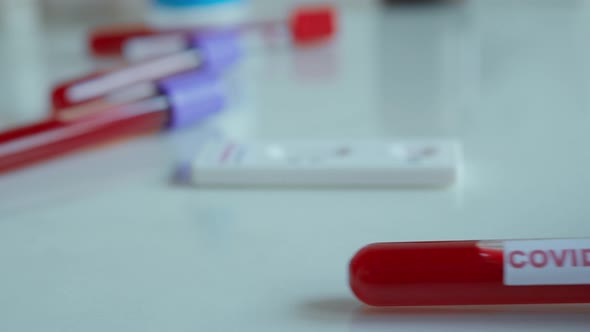 Close-up Doctor Hands Put on Table Test Tube with Blood Sample for COVID-19 Analyzing