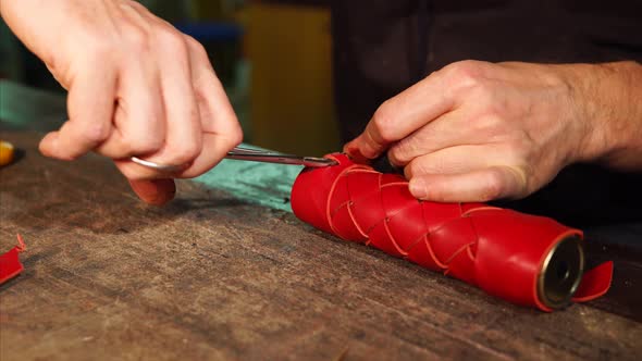 Master Is Fixing Edge of Leather Strip on a Red Casing for Kaleidoscope Tube