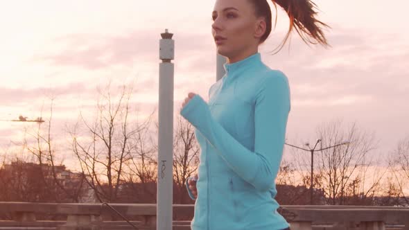 Young, beautiful and sporty woman having evening training outdoor.