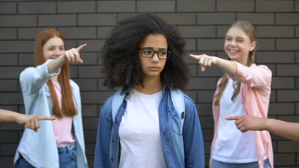 Mocking Classmates Pointing Fingers at Black Female Teenager in Eyeglasses