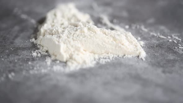 Baker cleans the flour from the table with a scraper. Close up video