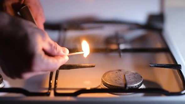 Ignition of a gas stove, close-up. Igniting a match and igniting gas