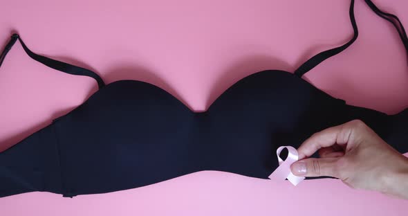 Pink Breast Cancer Awareness Ribbon Black Underwear and Hands on Pink Background