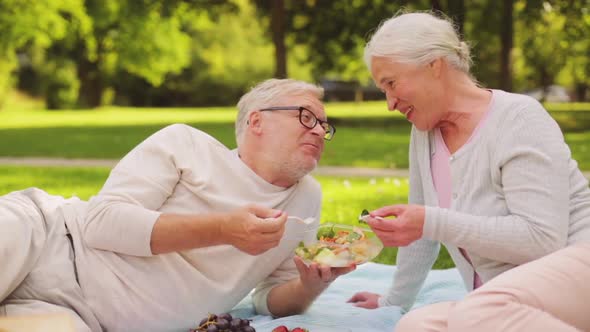 Senior Couple Eating Salad at Picnic in Park