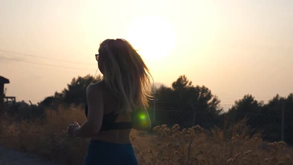 Follow To Sporty Girl Jogging in Country Road. Young Woman in Sunglasses Running Outdoors and