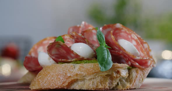 Bruschette with Salami and Mozarella is Sprinkled By the Raw Green Herbs in Slow Motion  60p Prores