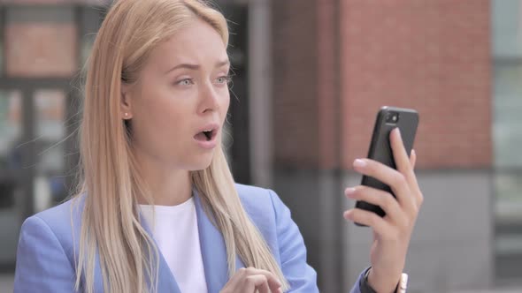 Outdoor Young Businesswoman reacting to Loss on Smartphone