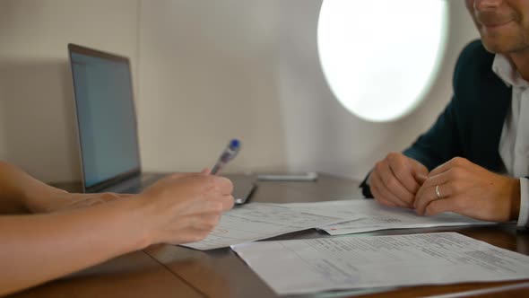 Businesspeople Signing Deal Agreement Inside of Private Jet