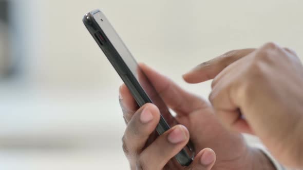 Close Up of African Man Using Smartphone Mobile