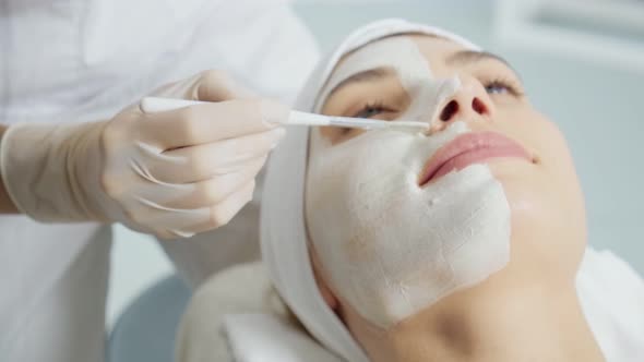 Young Woman Enjoying Applying Cosmetic Mask for Face