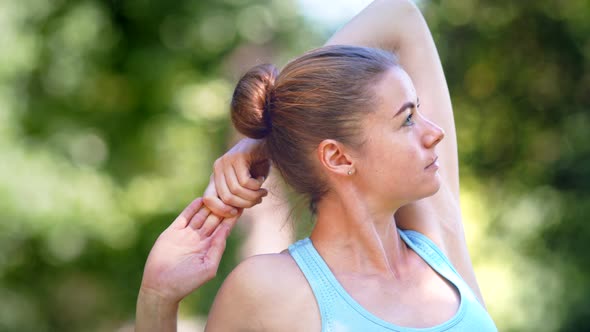 Professional lady athlete with fair hair bun in blue top