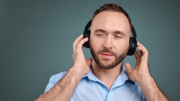 Closeup Portrait of Male Listening Music in Headphones Isolated