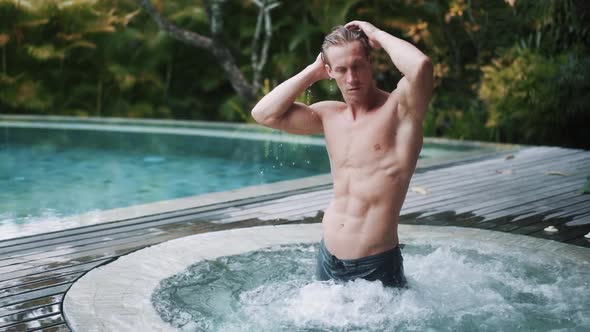 Handsome Man Stands in Pool at Tropical Resort Vacation Slow Motion