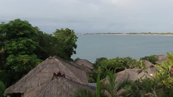 Flight of a Drone Over a Village on the Seashore