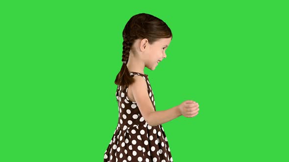 Smiling Little Girl in Polka Dot Dress Walking on a Green Screen Chroma Key