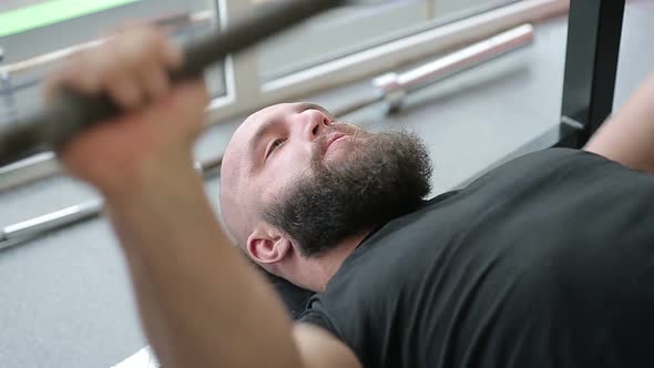 Strong Heavyweight Athlete Thoroughly Doing Barbell Exercise With Strained Face