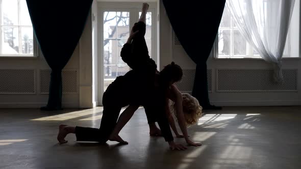 Contemporary Dancers are Rehearsing in Dance Hall Silhouettes of Young Man and Woman