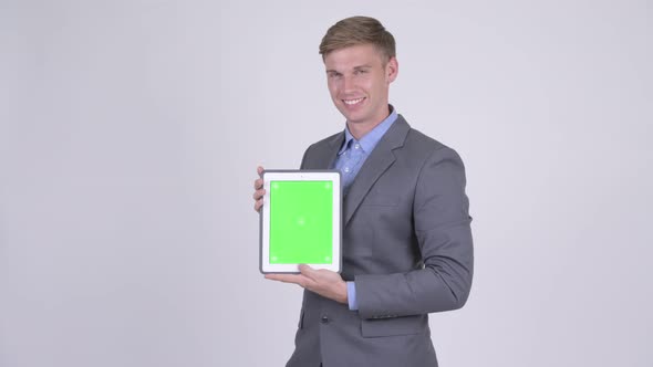 Happy Young Handsome Businessman Showing Digital Tablet