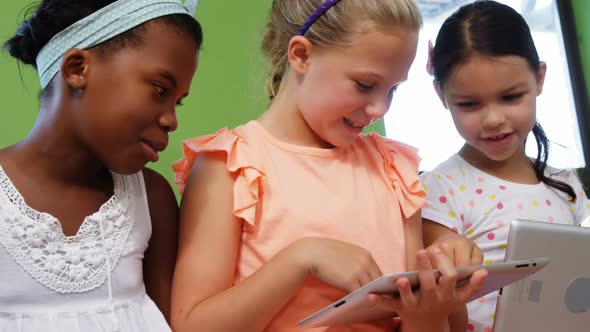 Schoolgirls using digital tablet