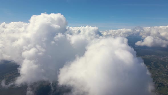 Aerial View From Airplane Window at High Altitude of Earth Covered with Puffy Cumulus Clouds Forming