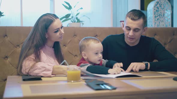 Family Sits at Brown Wooden Table and Communicates