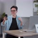 Young Positive Guy Video Chatting with Friends Via Smartphone Sitting at Modern Office Alone Slow - VideoHive Item for Sale