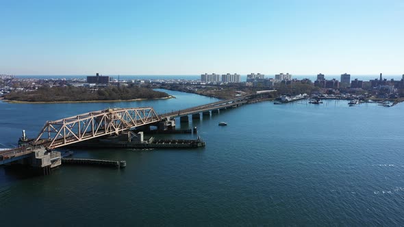 An aerial drone shot over Grassy Bay in Queens, NY. The camera dolly in over the waters & towards el