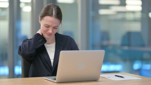 Young Businesswoman having Neck Pain while Typing on Laptop 