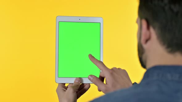 Man Using at Tablet with Chroma Screen, Yellow Background