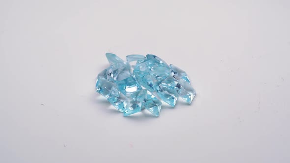 Natural Blue Topaz Gemstones on the White Background Turning Table