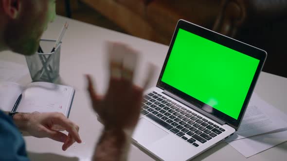 Bearded American Guy is Talking and Looking at Laptop Screen at Table in Apartment Spbas