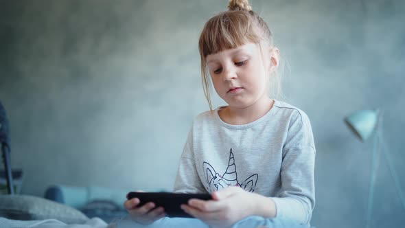 Education, School, Technology and Internet Concept - Little Student Girl with Smartphone